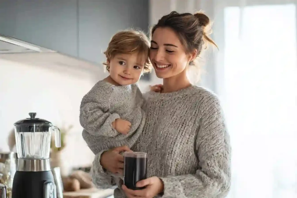 Smiling mom holding baby and drinking mushroom coffee safely during breastfeeding